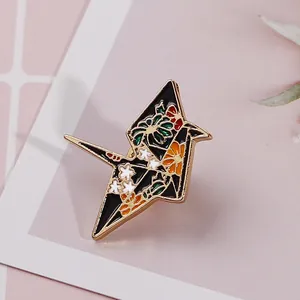 Floral enamel origami crane brooch with gold edges and colorful Japanese style patterns