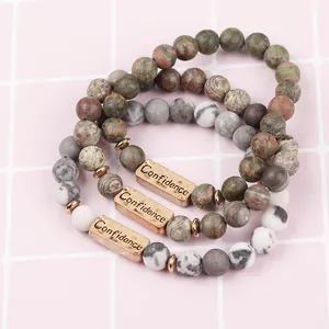 Detailed macro of three-piece beaded stone bracelets set with engraved Confidence bar