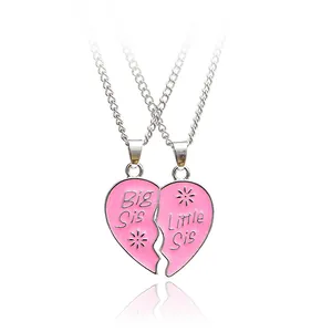 Detail view of pink heart-shaped pendant necklaces with Big Sis and Little Sis engravings