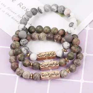 Detailed macro view of natural stone beads with Confidence engraved bronze plate