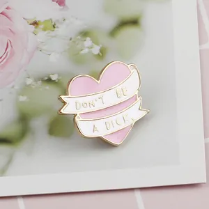 Pink heart enamel brooch with 'Don't be a Dick' ribbon design on floral backdrop