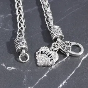 Silver-toned chain bracelet featuring a heart pendant with rhinestones and Believe text