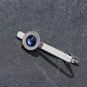 Silver necktie clip featuring a deep blue zircon gemstone on a textured metal frame
