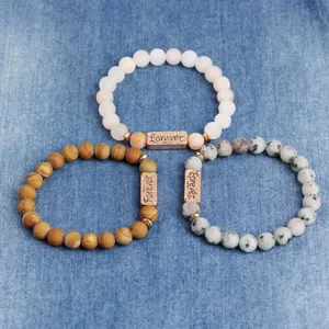 Detailed view of three natural stone bead bracelets with rose gold Forever engraving