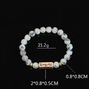 Detail of blue stone bead bracelet with Forever engraved rose gold charm and size specs