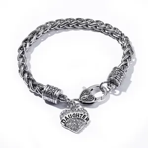 Detail of a chunky link bracelet featuring a rhinestone heart pendant with DAUGHTER text