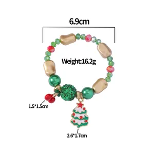 Detailed view of Christmas beaded bracelet with red cherries and white tree charms