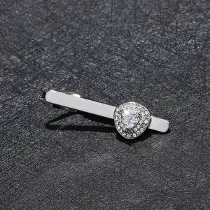 Macro view of silver necktie clip featuring a heart-shaped zircon and pave rhinestones