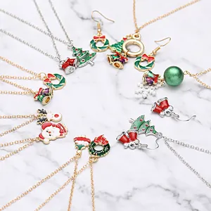 Weihnachts-Schmuckset mit bunten Emaille-Halsketten und Ohrringen auf Marmorhintergrund