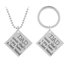 Macro shot of silver stainless steel keychain and necklace set with engraved Dad definition