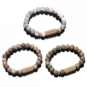 Three natural stone bead bracelets with Confidence engraved metal tags on white background
