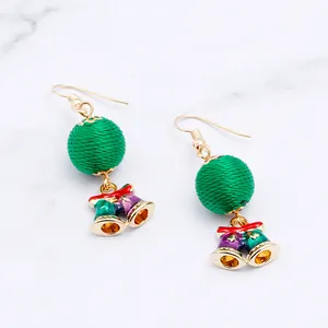 Detailed shot of Christmas earrings featuring green thread balls and colorful mini bells