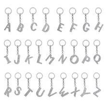 Macro shot of 26 silver alloy alphabet keychains encrusted with sparkling white rhinestones