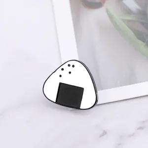 Χαριτωμένη ιαπωνική καρφίτσα σμάλτου Onigiri σούσι σε λευκό μάρμαρο σκηνικό
