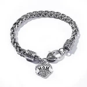 Macro detail of silver twisted chain bracelet with crystal heart MOM pendant charm