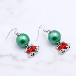Detailed view of Christmas drop earrings with green glitter beads and red twin bells