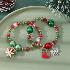 Christmas beaded bracelet set with snowflake and stocking charms on a ceramic tray