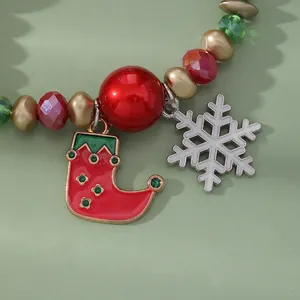 Macro detail of Christmas beaded bracelet with enamel stocking and snowflake charms