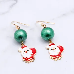 Detailed macro view of festive Santa Claus earrings with green beads and gold fish hooks