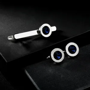 Detailed macro view of silver cufflink and tie clip set with blue faceted crystal stones
