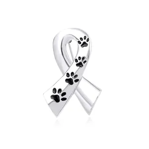 Detailed view of silver ribbon brooch featuring black enamel paw prints and polished finish