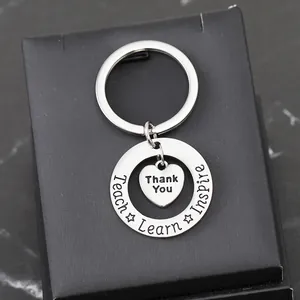 Detailed macro view of heart charm keychain with Teach Learn Inspire engraving