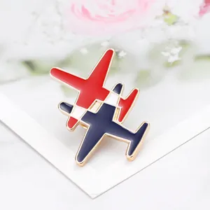 Gros plan d'une broche avion en émail rouge et bleu avec une base en métal doré poli