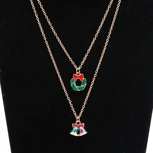 Details einer zweilagigen Goldkette mit Emaille-Weihnachtskranz und Glockenanhängern