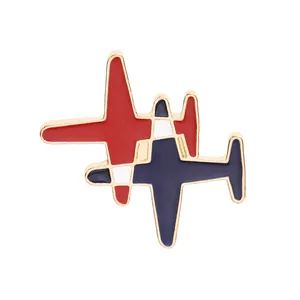 Détail de la broche avion en émail rouge et bleu avec bords dorés et finition rayée
