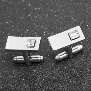 Silver cufflinks with square crystal on black glitter background shown at a 45-degree angle