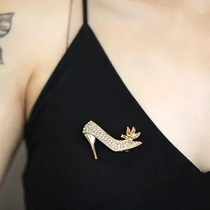 Elegant gold high heel shoe brooch with sparkling rhinestones and butterfly detail