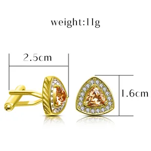 Golden triangular cufflinks with orange zircon center and white diamonds on white background