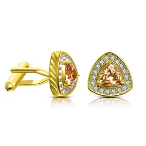 Detail of gold cufflinks featuring a triangular orange zircon and white crystal border