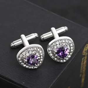 Detailed shot of silver cufflinks with purple triangle gemstone and double halo crystals