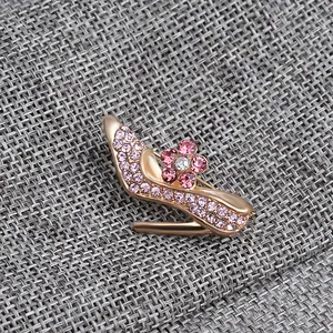 Macro detail of high heel brooch with pink rhinestones and golden alloy finish