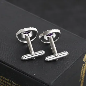 Polished silver cufflinks with purple round zircon stones on a black gift box base