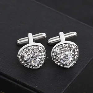 Macro detail of silver men's cufflinks with triangular zircon stones on black velvet