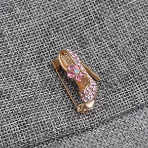 Detailed view of rhinestone high heel brooch with pink flower and gold metal finish