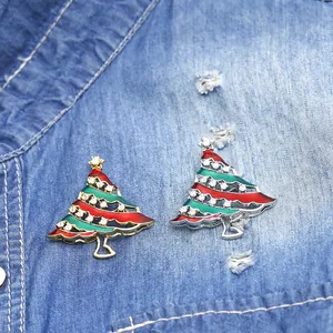 Christmas tree brooch with colorful enamel and sparkling zircons on denim background