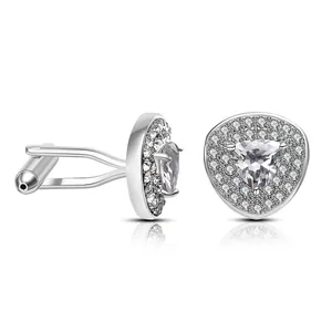 Macro shot of silver metal cufflinks with central triangle stone and pave diamonds