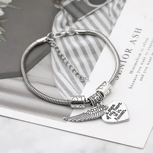 Detailed view of silver snake chain bracelet with heart wing charms and love beads