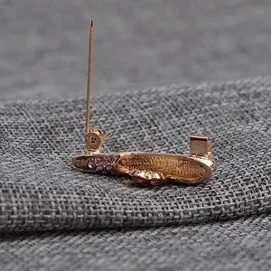 Detail of rose gold high heel brooch featuring pink rhinestones and a secure pin clasp