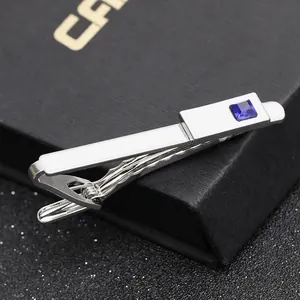 Macro detail of silver tie clip with square blue sapphire on black jewelry box