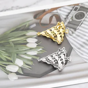 Detail view of gold and silver Christmas tree brooches showing secure metal back pins