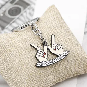 Detailed macro view of Whatever Forever hand gesture keychain with red nail polish detail