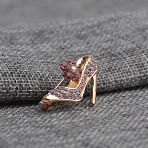 Detail of high heel brooch featuring purple rhinestones and pink crystal flower decoration