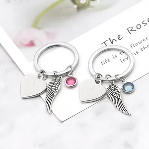 Detail of heart, wing and gem charms on polished silver keychain and bracelet pendants