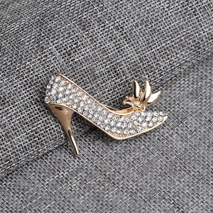 Detailed close-up of a sparkling gold-tone high heel brooch with crystal rhinestones