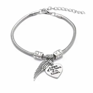 Silver snake chain bracelet featuring heart pendants and wings with memorial engraving