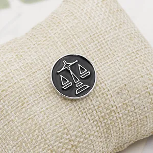 Detailed view of Libra zodiac enamel pin badge on a rustic linen fabric background